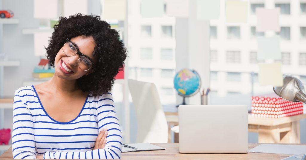 Portrait of woman in spectacles smiling against school background